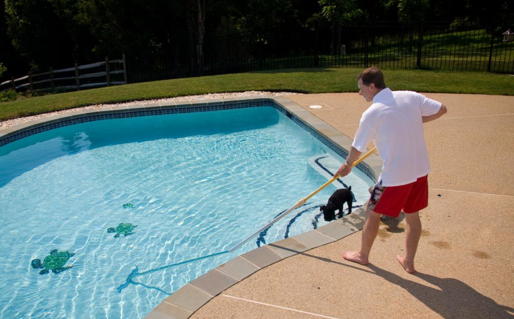 man cleaning the swimming pool